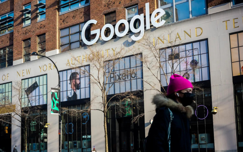 Woman walking in front of a building with a Google sign