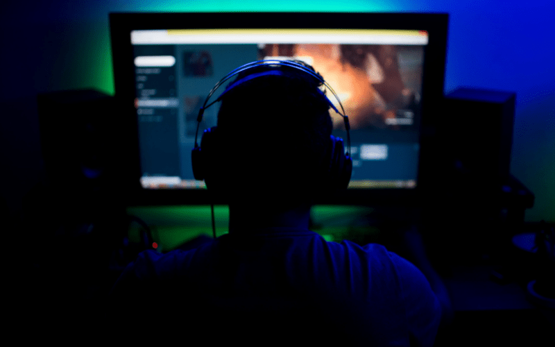 An adult male is playing games with his headphones