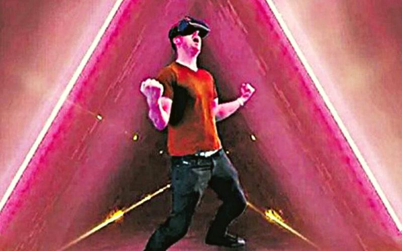 A gamer with VR headsets on makes a celebratory gesture