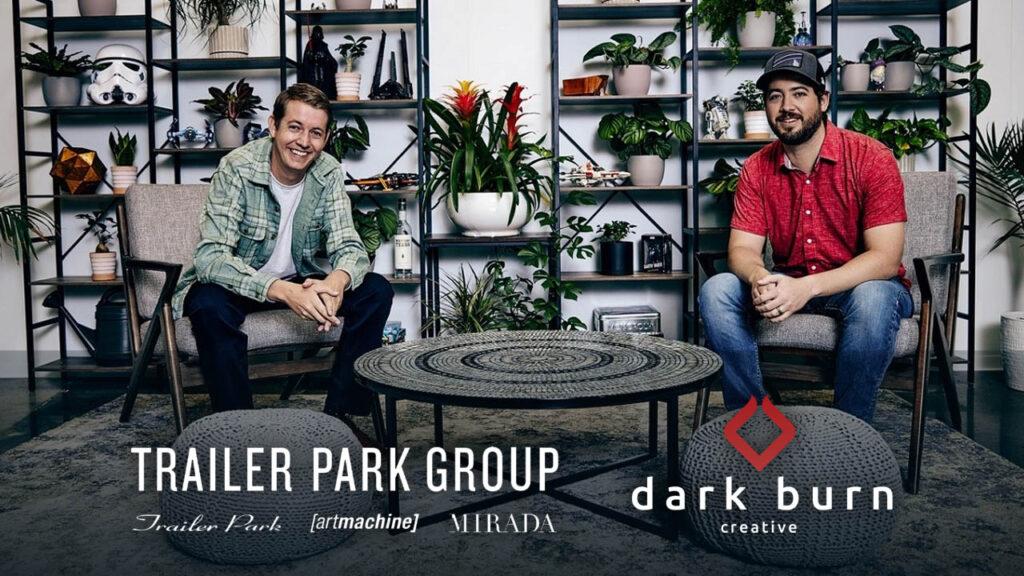 Tanner and Chase Boyajian smiling for the camera at their office with company logos