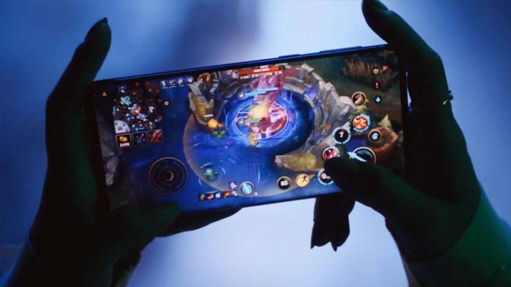 A pair of hands holding holding a phone and playing mobile game