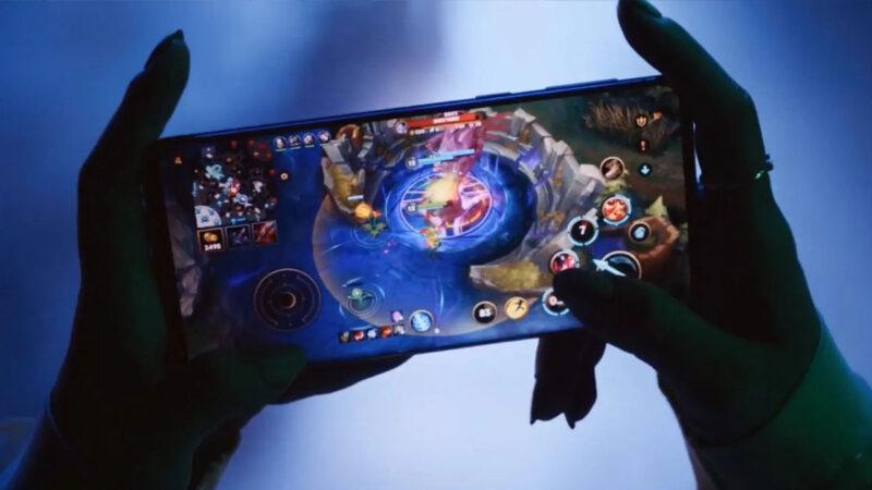 A pair of hands holding holding a phone and playing mobile game