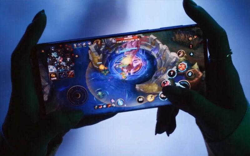 A pair of hands holding holding a phone and playing mobile game