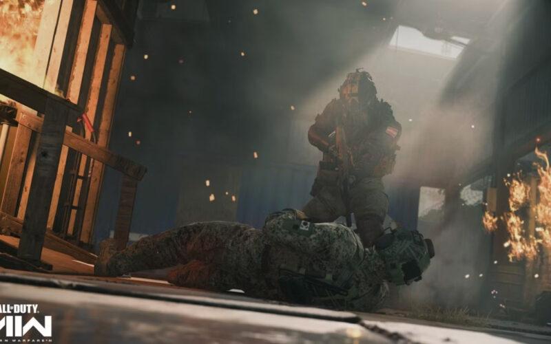 A soldier trying to help out another soldier out from a burning warehouse