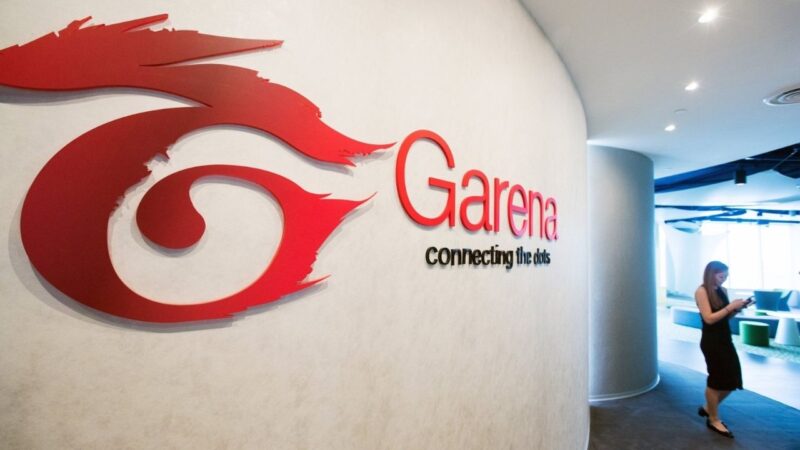 A walking woman and Garena logo on a white wall
