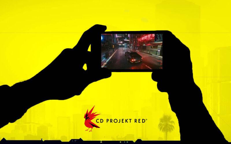 Silhouette of a pair of hands playing Cyberpunk on a mobile phone