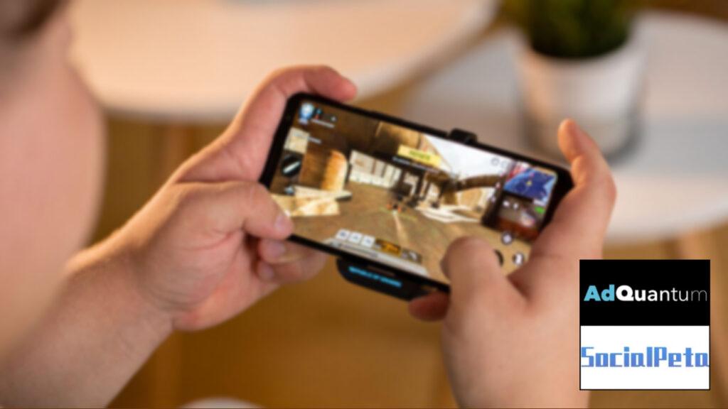 A blurred image of a person playing mobile games next to AdQuantum and Social Peta logos
