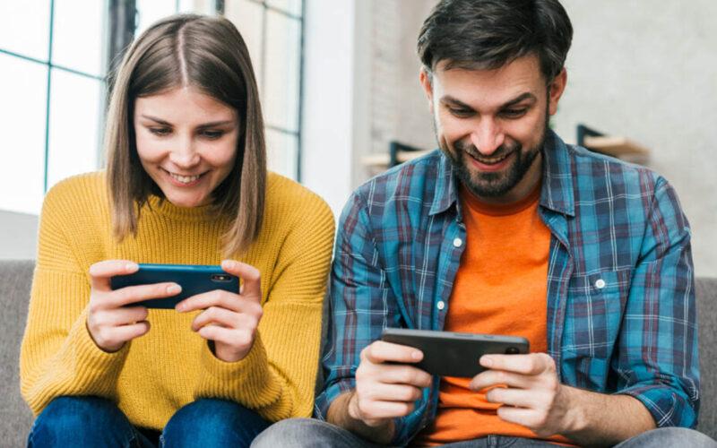 a woman and a man playing mobile games