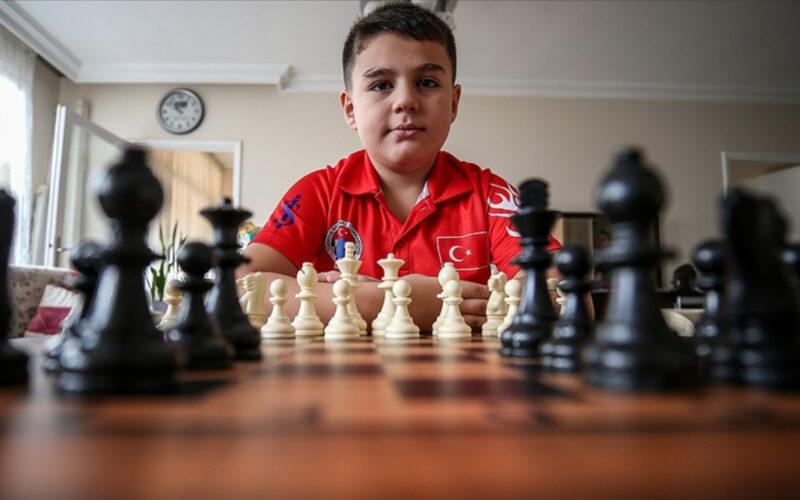 Yağız Kaan Erdoğmuş satranç masasının önünde oturarak poz veriyor