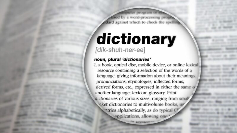 The word dictionary magnified on a dictionary page.
