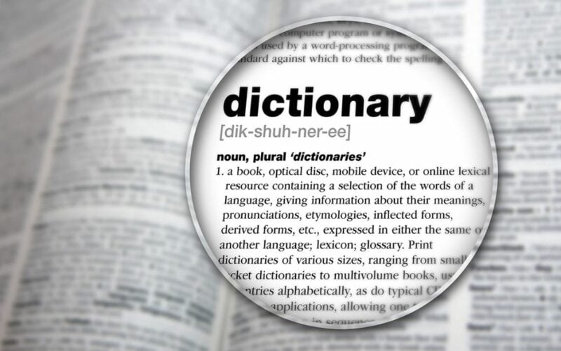 The word dictionary magnified on a dictionary page.