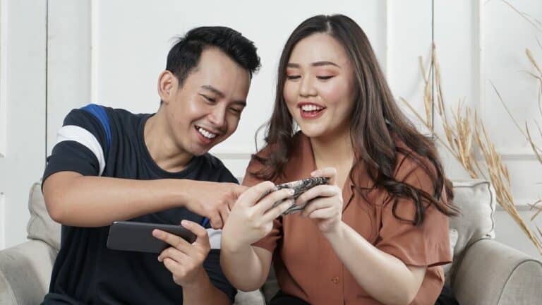 two people from different ethnicities playing a mobile game