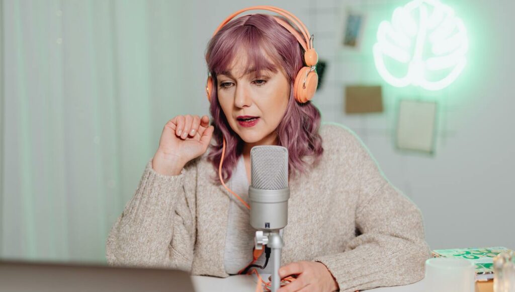 influencer girl making a video on a topic with headphones laptop and microphone