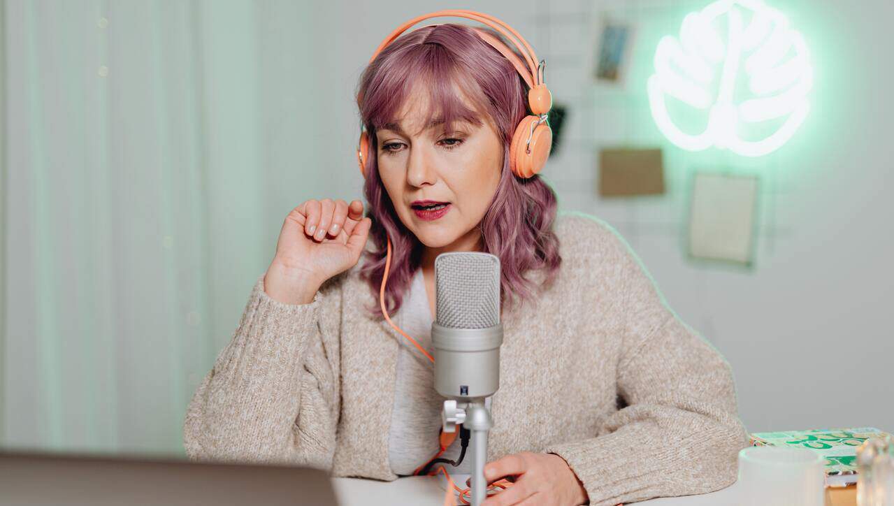 influencer girl making a video on a topic with headphones laptop and microphone