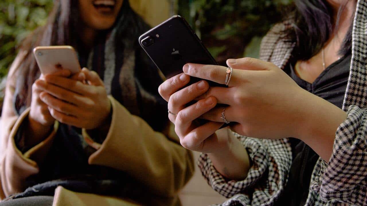 women holding iphones