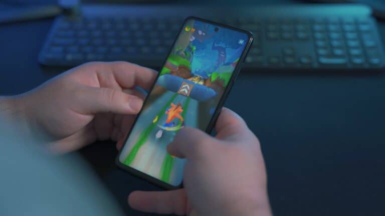 man playing a hypercasual game with a keyboard in the background