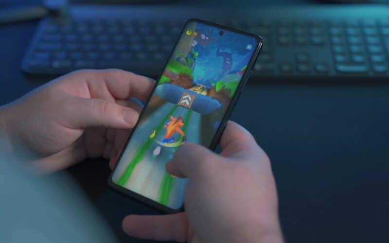 man playing a hypercasual game with a keyboard in the background