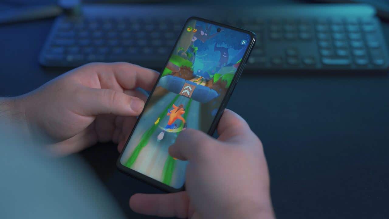 man playing a hypercasual game with a keyboard in the background