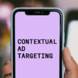 contextual ad targeting is written on a mobile phone in front of a blurry background