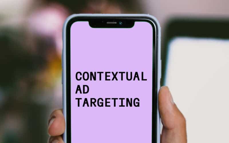 contextual ad targeting is written on a mobile phone in front of a blurry background