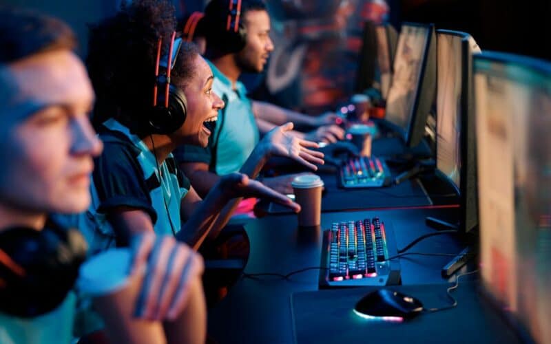 cover image for the article, "How to build an engaged game community beyond Twitter (X)" featuring various gamers together in front of PCs.