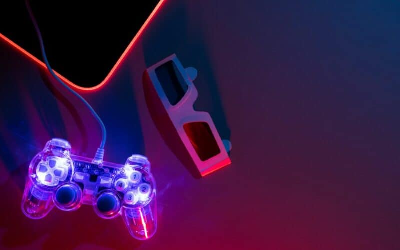 game controller and 3d glasses on a dimly lit desk.