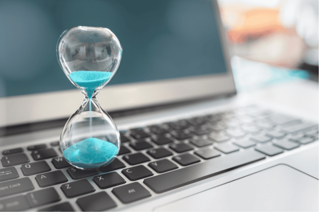 a hourglass sitting on top of a lapto pfor the payback period matters article by deniz kekeç