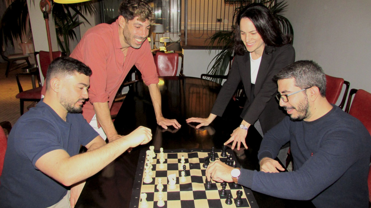 Zoe Studios team photo where they play chess (2 people playing, other 2 watching)